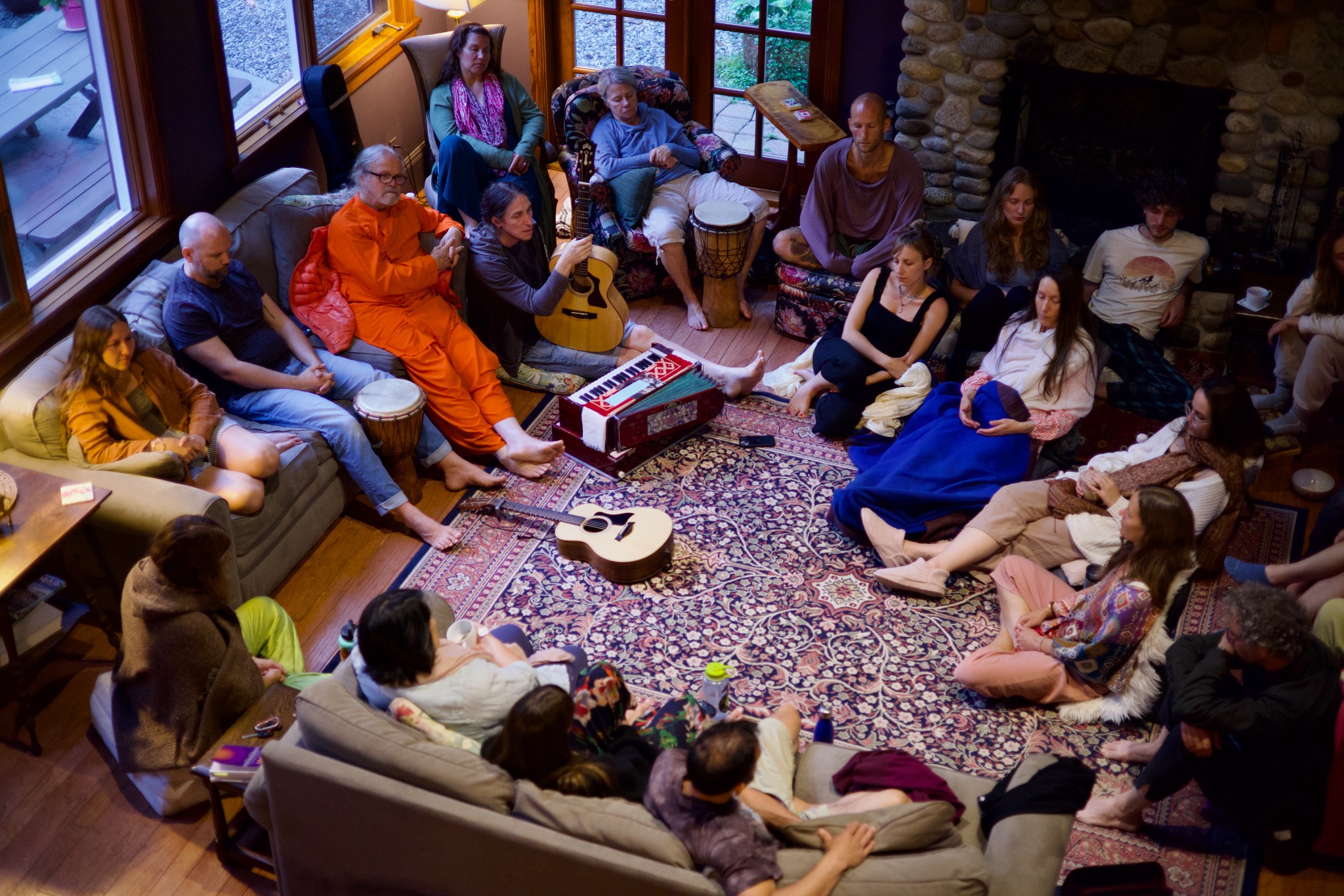The retreat community gathered with instruments beside the stone fireplace at Linwood House